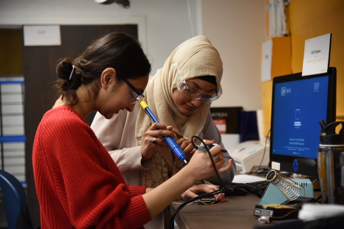 2 students soldering 