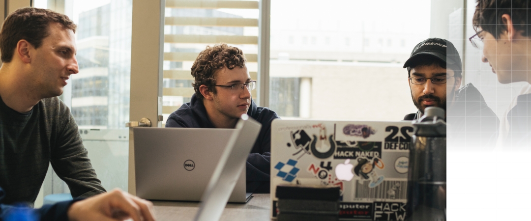 students working on laptops around a table