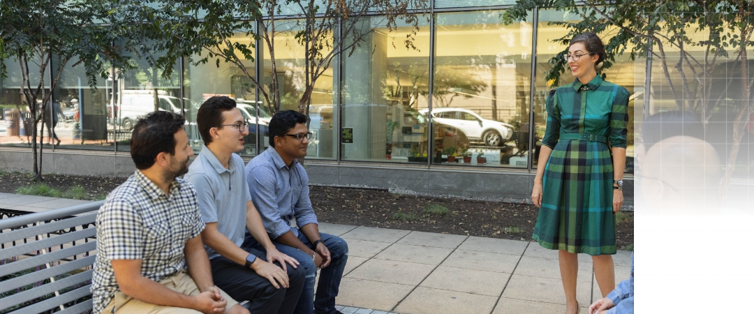 students and professor sitting outside of the science and engineering hall