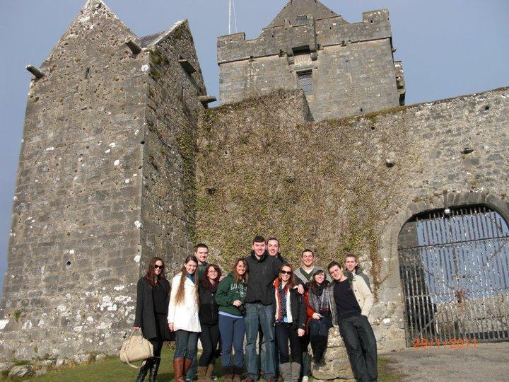 Students standing inform of historic building