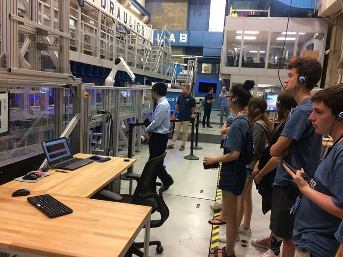 students standing in lab listening to professor