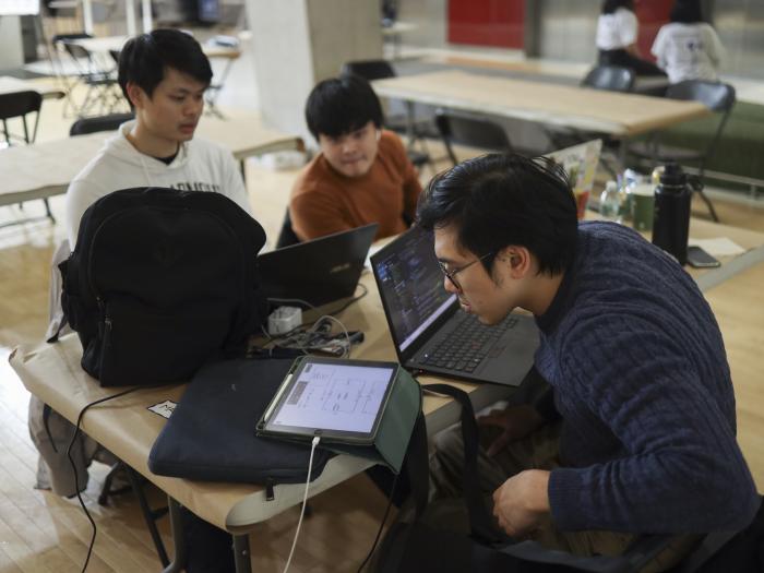 Juniors Si Ming Zhou, Siah Wee Hung, and Khoo Yong Hui working on their hackathon project