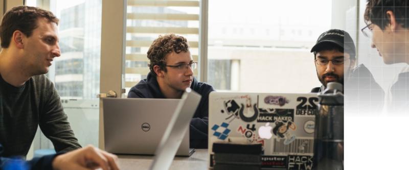 students working on laptops around a table
