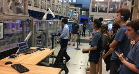 students standing in lab listening to professor